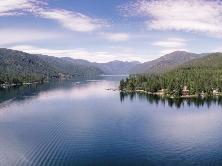 Aerial photo of Christina Lake surrounded by forested mountains.